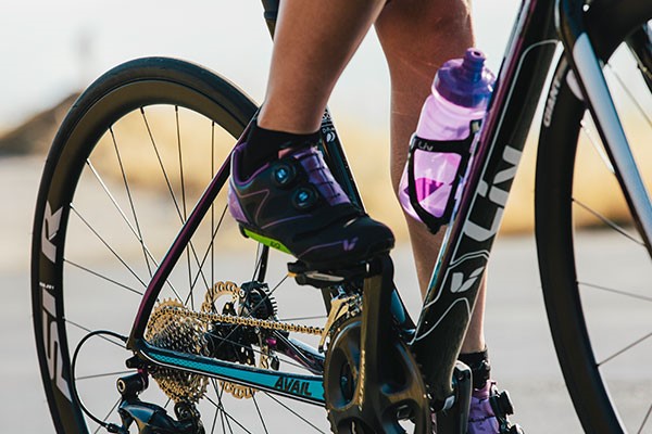 A Women cyclist on a Liv bike with a bottle cage and bottle on show